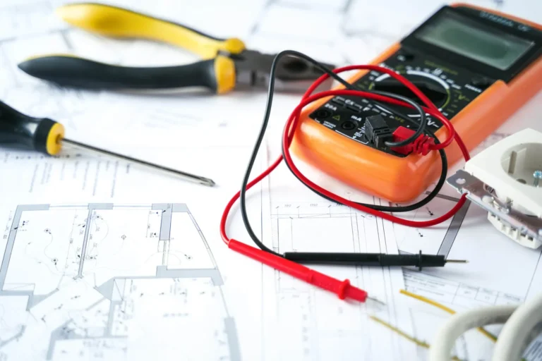 Electrical tools and circuit diagrams on a desk.