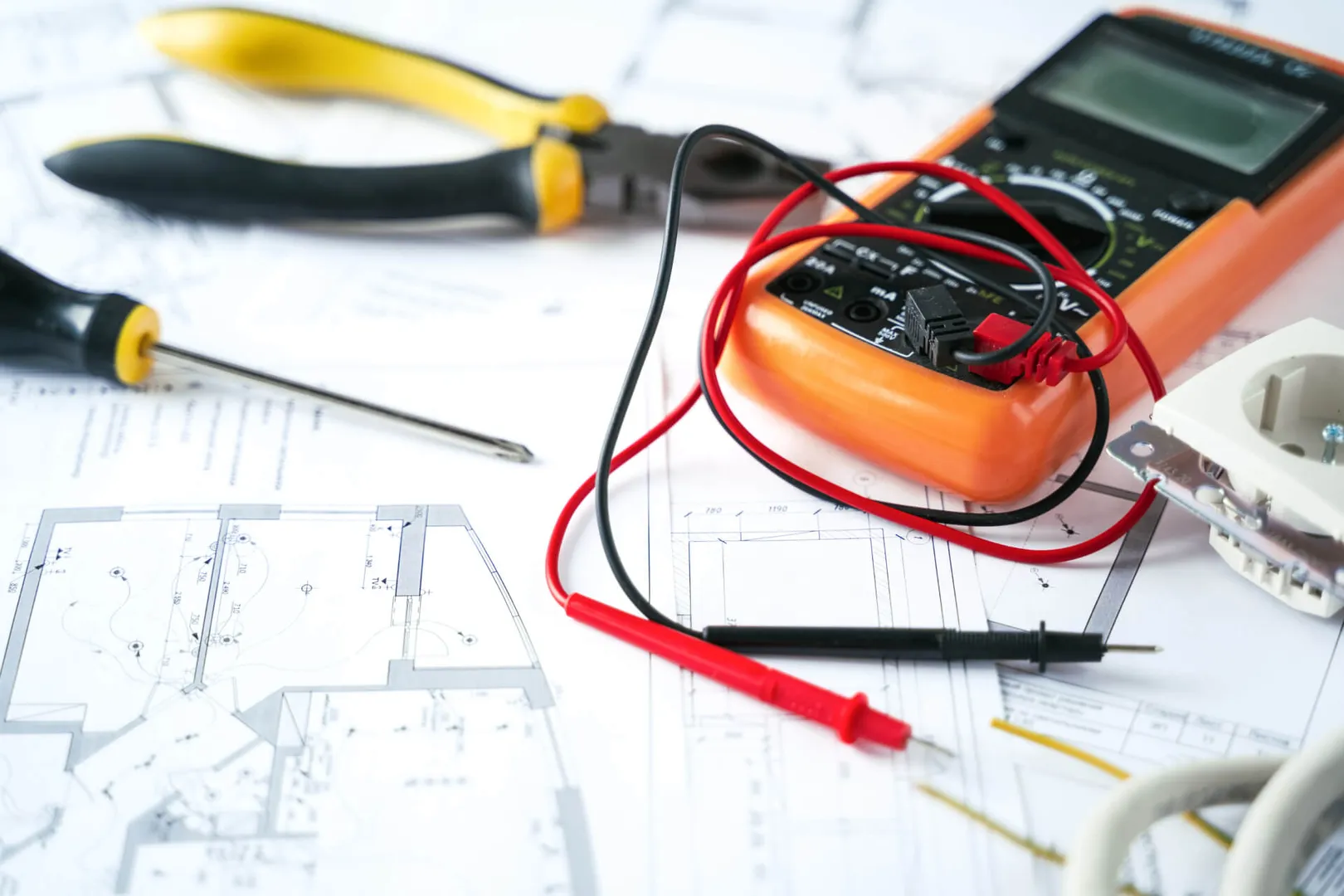 Electrical tools and circuit diagrams on a desk.